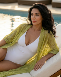 Natalie Noor wearing the Sillage robe, in textured Lime Bloom cotton, by the pool. A luxury Sahara Resort Wear Collection by Natalie Noor.