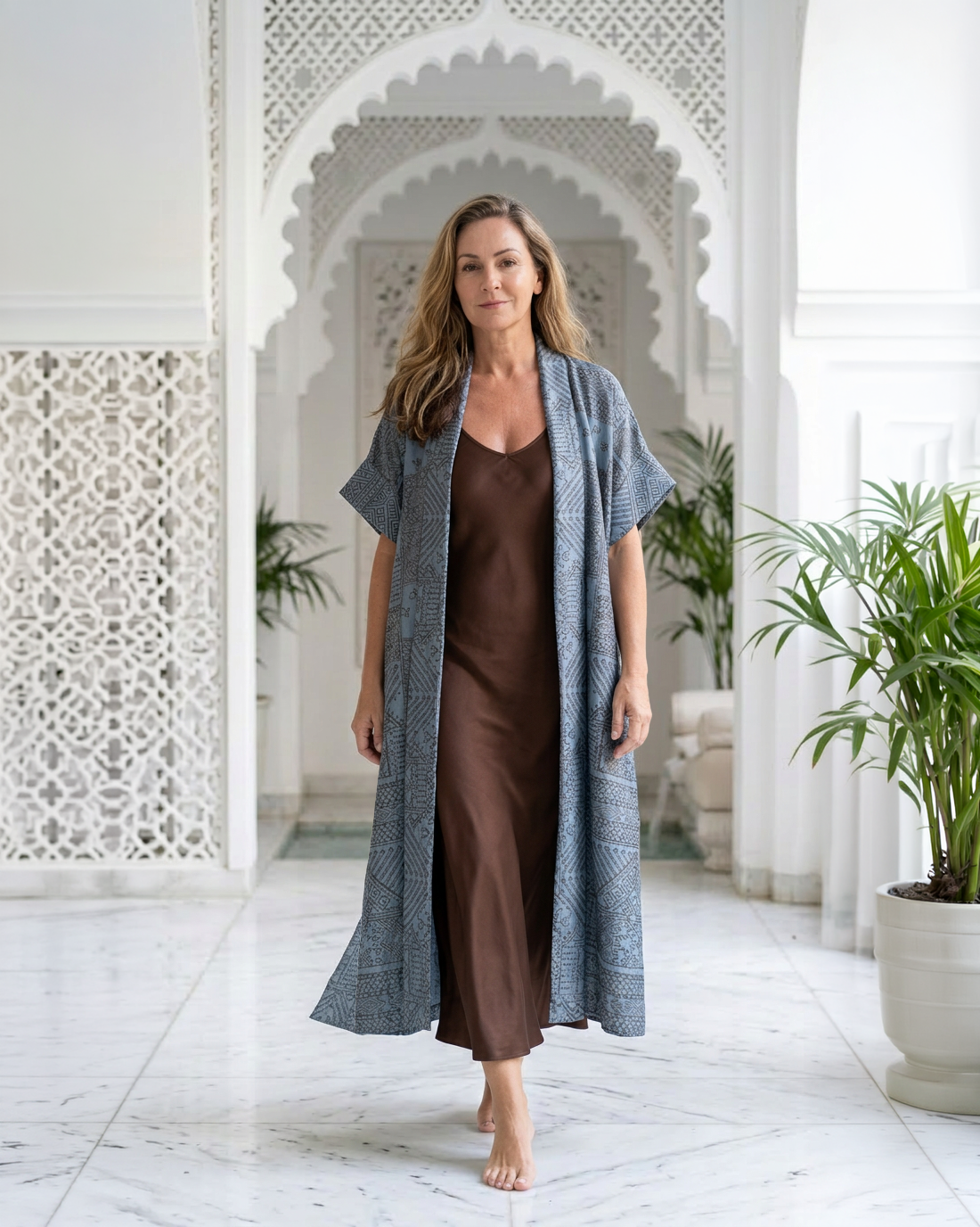 Natalie Noor wearing the moonstone blue Mirage robe with intricate metallic black and gold embroidery. A Luxury Sahara Resort Wear collection.