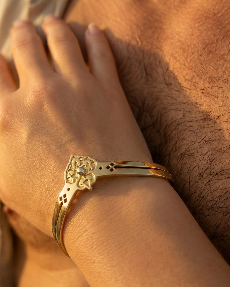 Golden cuff bracelet on a wrist with a blurred background. Maison Natalie Noor, jewelry lit by Desire.