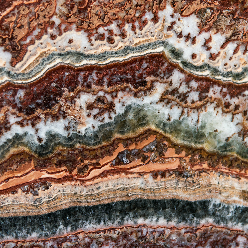 Close-up of layered gemstone with brown, white, and green colors. Jewelry Lit by Desire - Natalie Noor