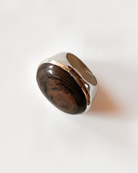 Ring with copper obsidian gemstone and silver band on a white background