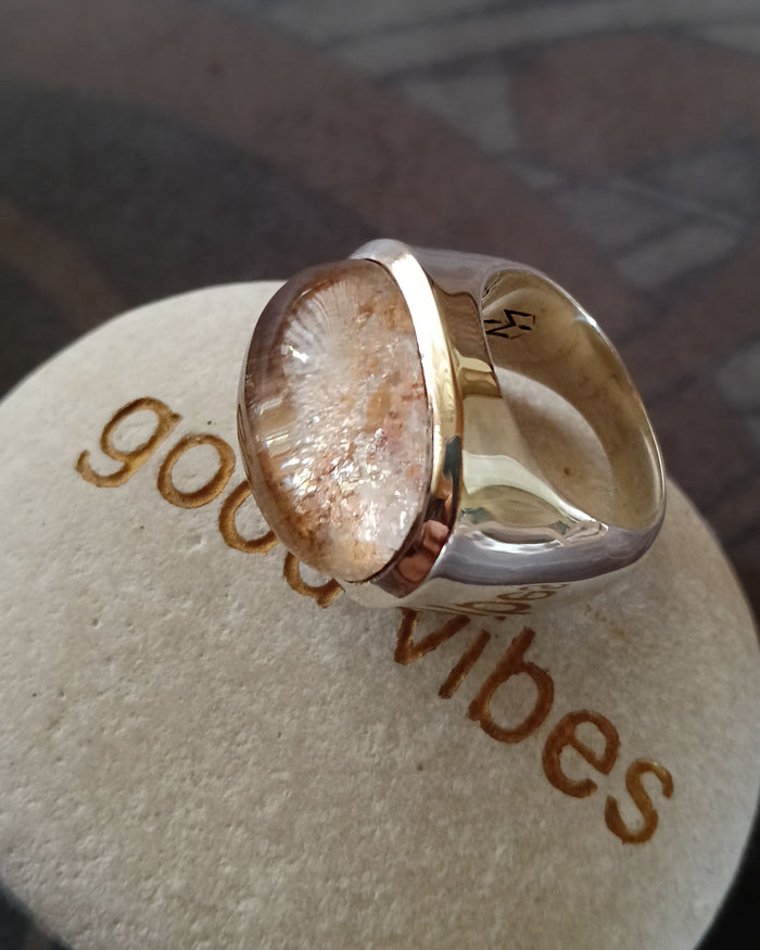 Gold and silver ring on a 'good vibes' jewelry cushion.