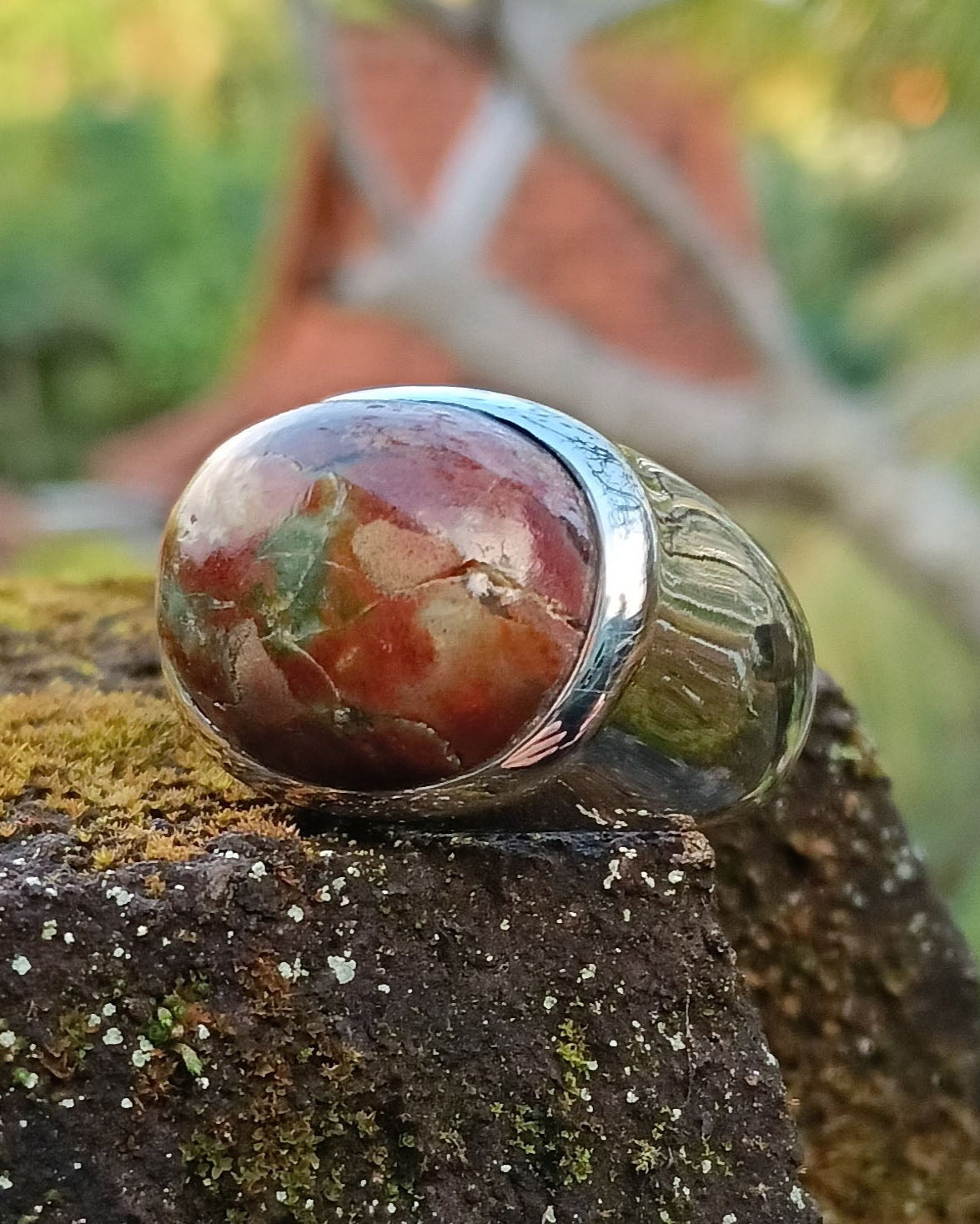 Signet ring with a large, multicolored pancawarna gemstone on a natural background. Maison Natalie ~Noor, jewelry lit by desire.