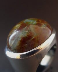 Signet ring with a large, oval, multicolored pamcawarna gemstone on a dark background. Maison Natalie Noor, jewelry lit by desire.