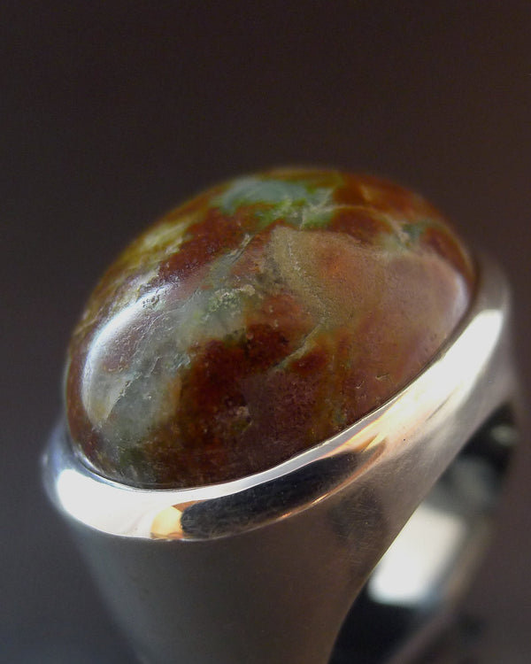 Signet ring with a large, oval, multicolored pamcawarna gemstone on a dark background. Maison Natalie Noor, jewelry lit by desire.